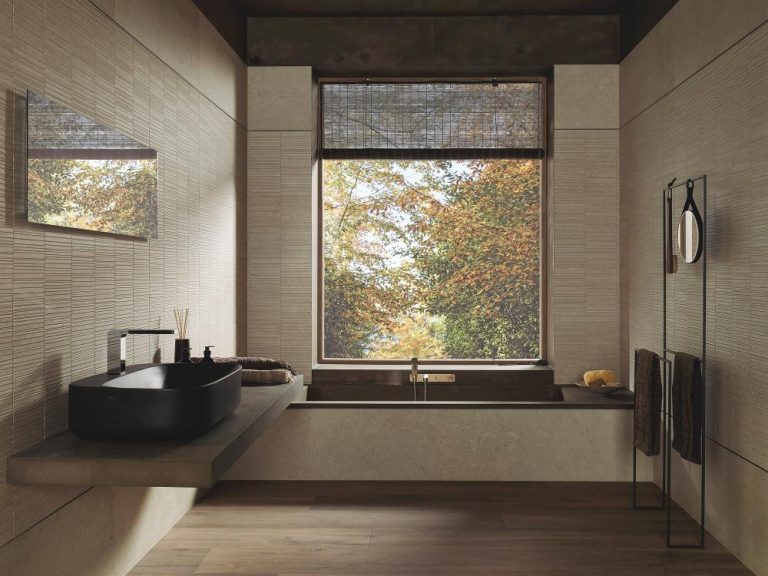 Béžová koupelna s 3d obkladem s mozaikou, černé umyvadlo na desce, dlažba s imitací dřeva