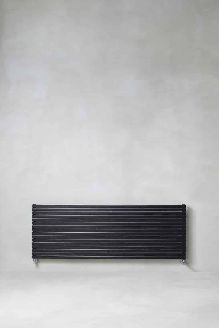 Betonová stěrka a černý radiátor na zdi