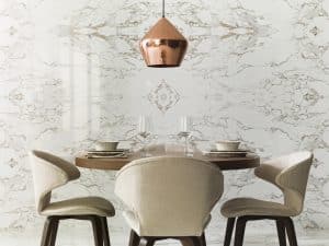 jídelna s mramorovým bílým obkladem, bronzový lustr, kulatý stolek s béžovými polstrovanými židlemi
