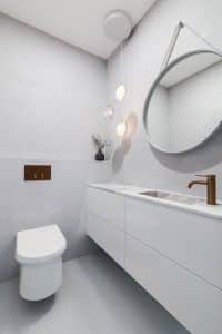 Toaleta s bílým mramorovým umyvadlem zapuštěným do desky, umyvadlová bílá skříňka