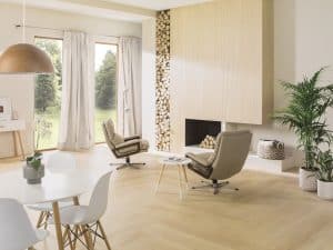Obývací pokoj s krbem obloženým dřevěným obkladem, zásobník na dřevo, světlá dřevěná podlaha, bílý stůl a židle