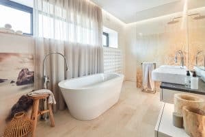 Koupelna, dlažba dřevo, volně stojící vana a baterie, dřevěné doplňky a dekorace, skleněná sprchová zástěna