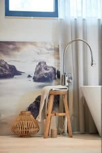 Vanová baterie z podlahy, dřevěná stolička a dekorace v koupelně