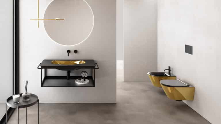 Koupelna se zlatým umyvadlem, černá umyvadlová skříňka, zlatá toaleta a bidet, černé sedátko